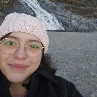 Photo of Brandilyn Castro in front of a waterfall.