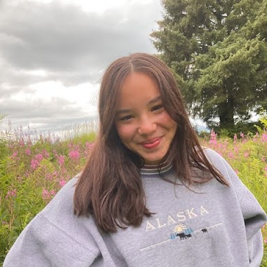 Photo of Nancy Liddle in front of a field of fireweed